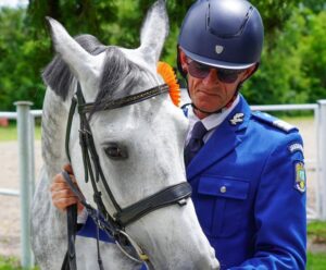 Jandarm alături de un cal alb