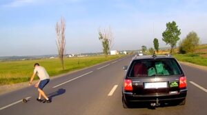 Un șofer se dă jos din mașină să salveze o pisică din trafic.