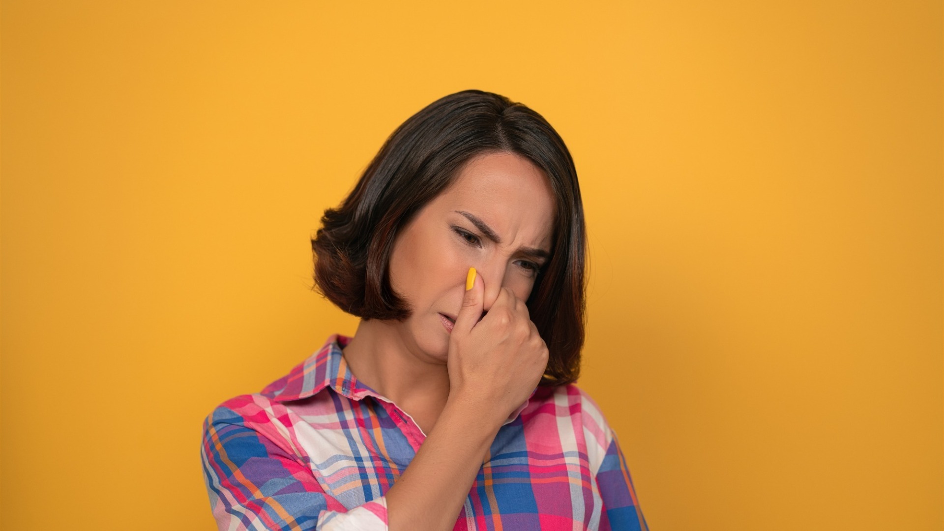 Femeie care tine mana la nas din cauza mirosului.