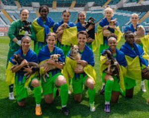 Fotbaliste care țin căței în brațe.