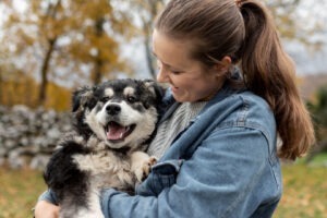 O femeie ține un câine în brațe