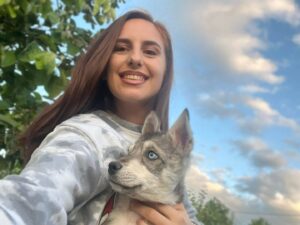 O tânără ține în brațe un cățel