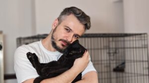 Adrian Popa ține în brațe o pisică neagră