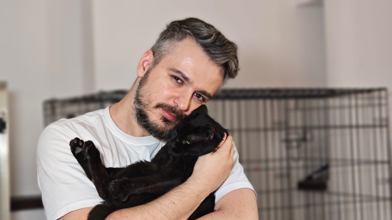 Adrian Popa ține în brațe o pisică neagră