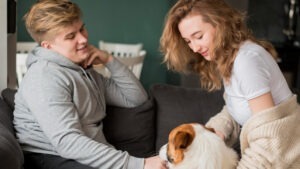 Doi tineri alături de un câine