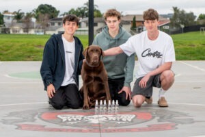 Trei tineri alături de un câine