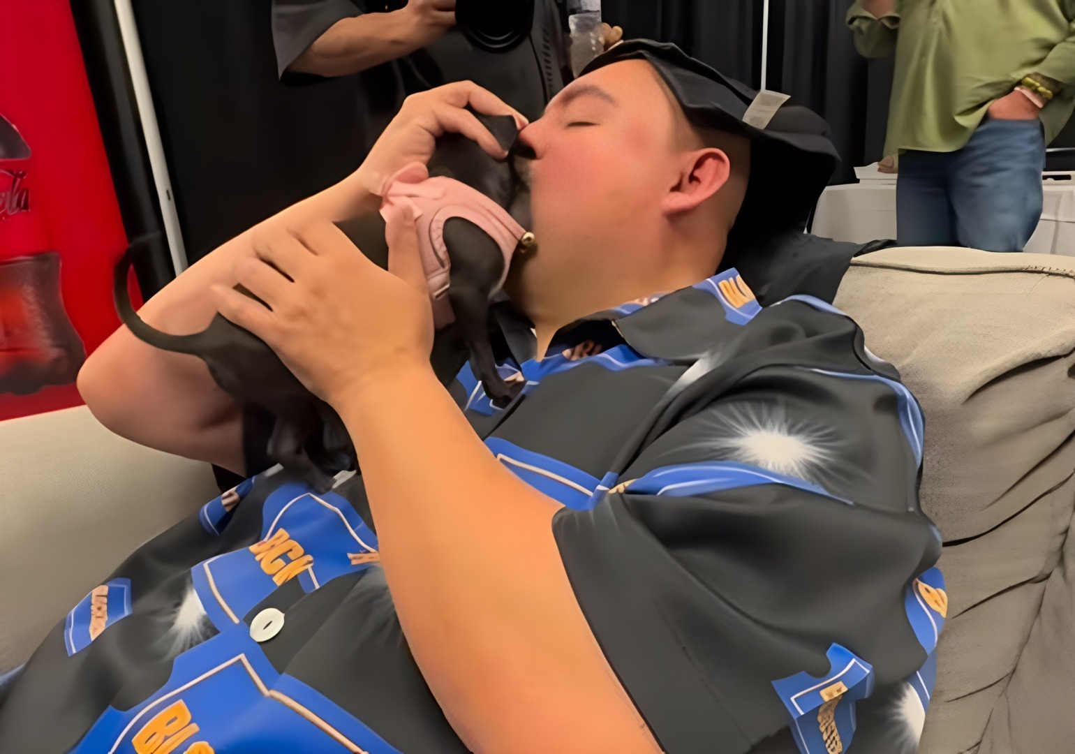 Un bărbat își ține câinele în brațe