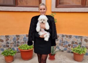 O tânără ține în brațe un cățel