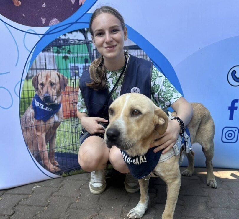 Tânără voluntară la Protecția Animalelor Sector 1, alături de un câine