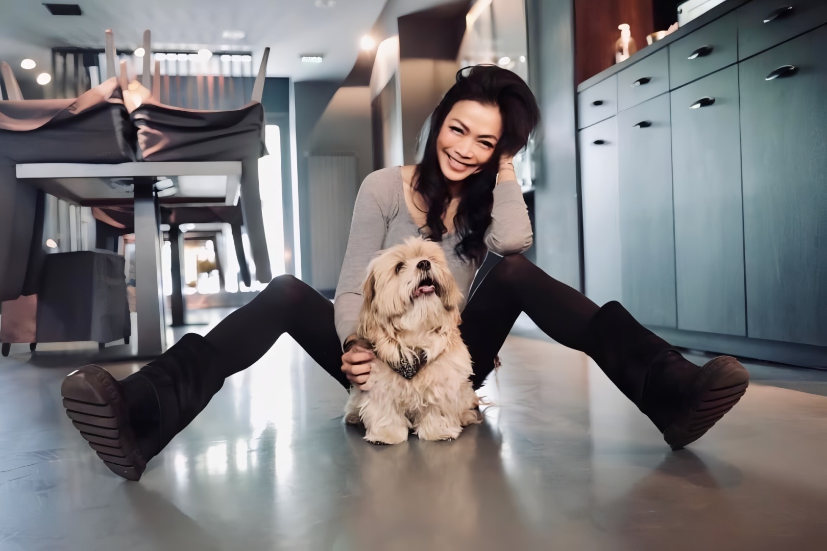 O tânără din Thailanda alături de cățelul ei, în bucătărie