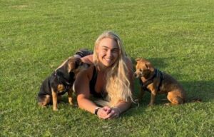 Instructor de fitness în iarbă, alături de doi căței