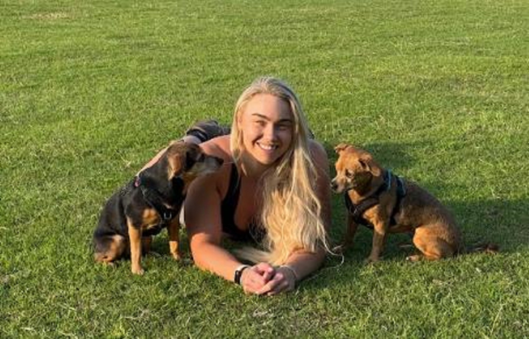 Instructor de fitness în iarbă, alături de doi căței