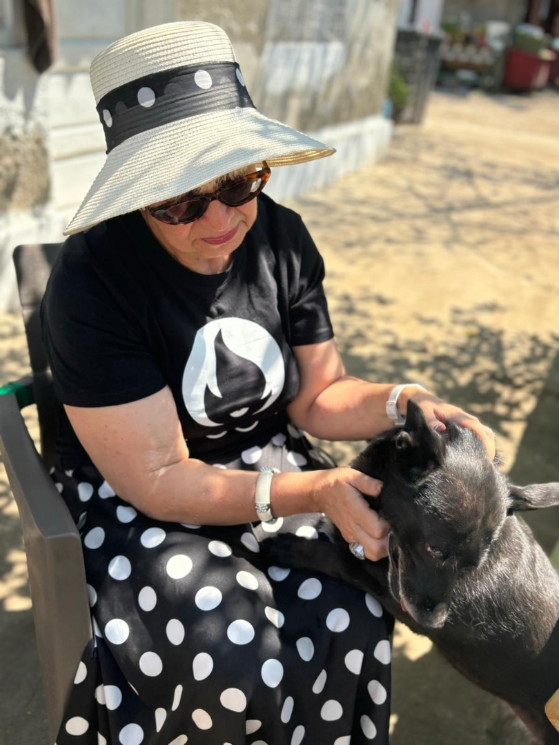 Margareta Nistor se joacă cu un câine negru