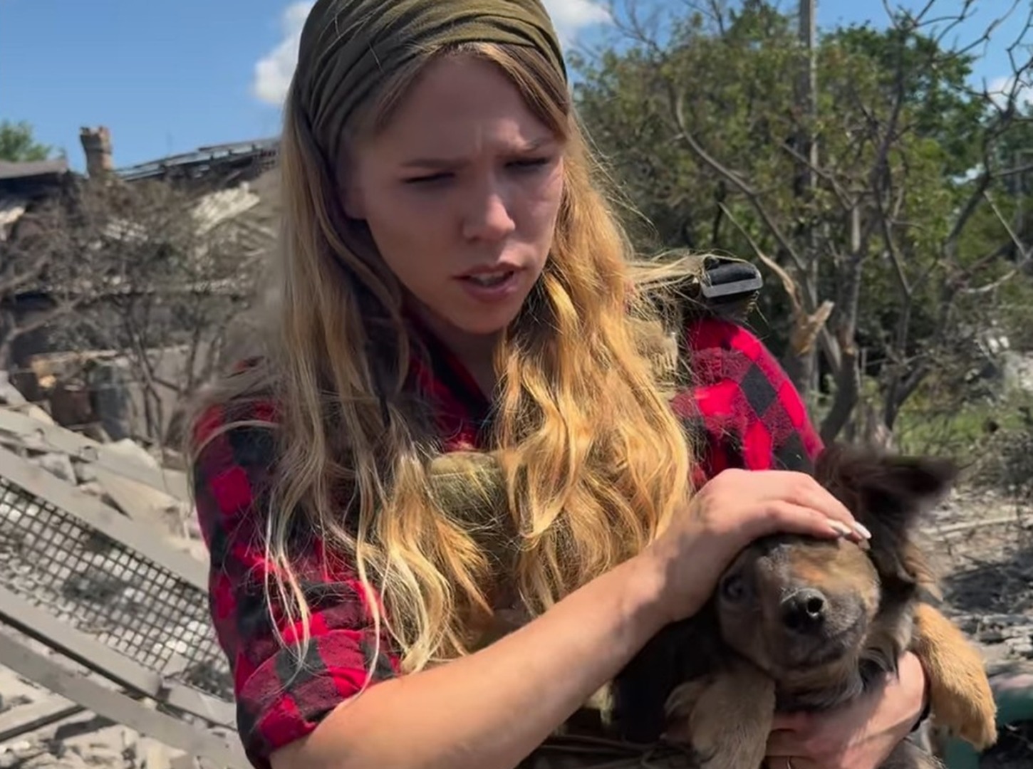 O tânără ține un câine în brațe, în urma unui bombardament în ucraina