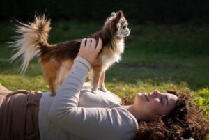 cainele si stapana stau pe iarba