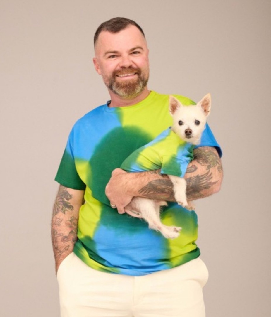 Bărbat asortat cu câinele său în tricouri colorate cu albastru, verde și galben