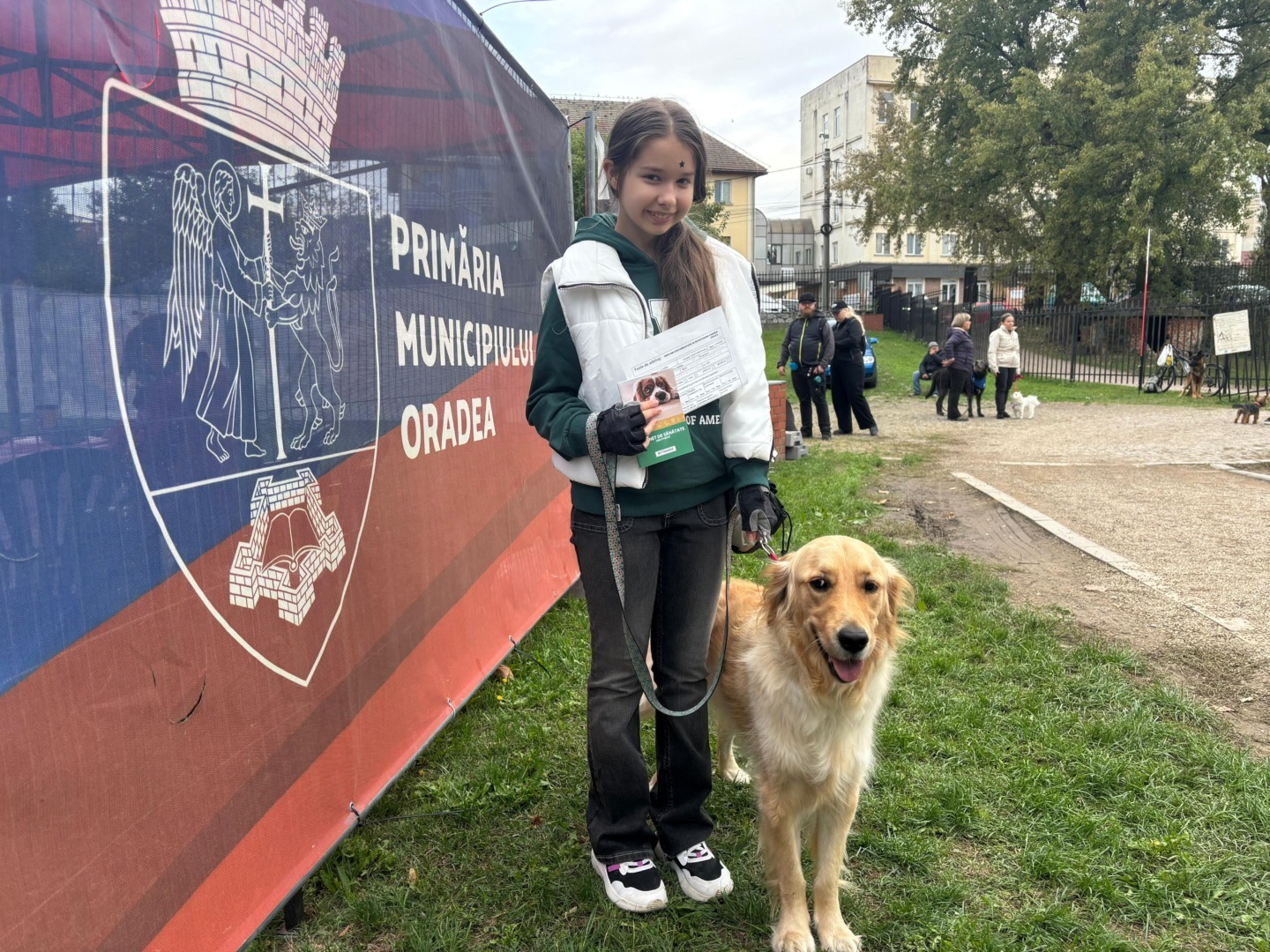 O elevă alături de câinele ei, lângă un panou informativ