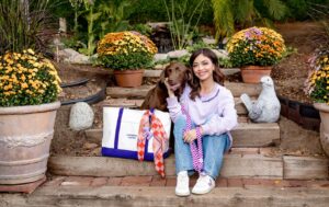 Sarah Hyland alături de un câine, în fața unor aranjamente florale