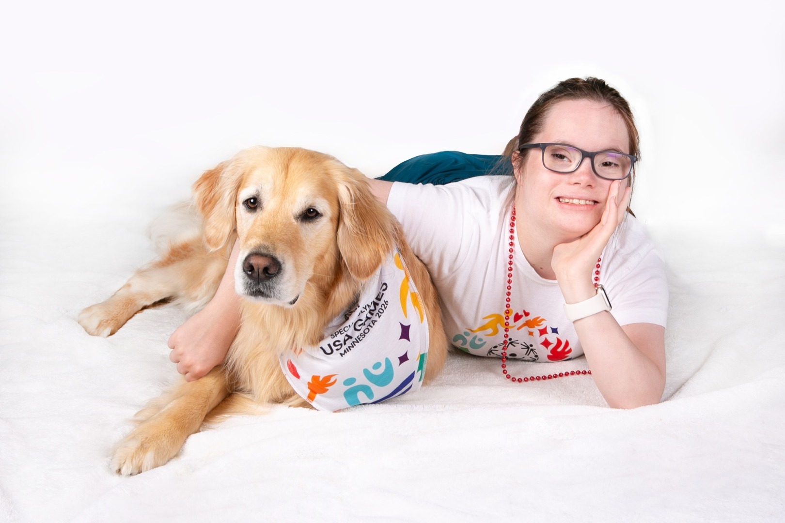 Champ, un golden retriever, mascota Special Olympics 2026, alături de o sportivă din echipa SUA