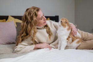 Pisică cu femeie în pat