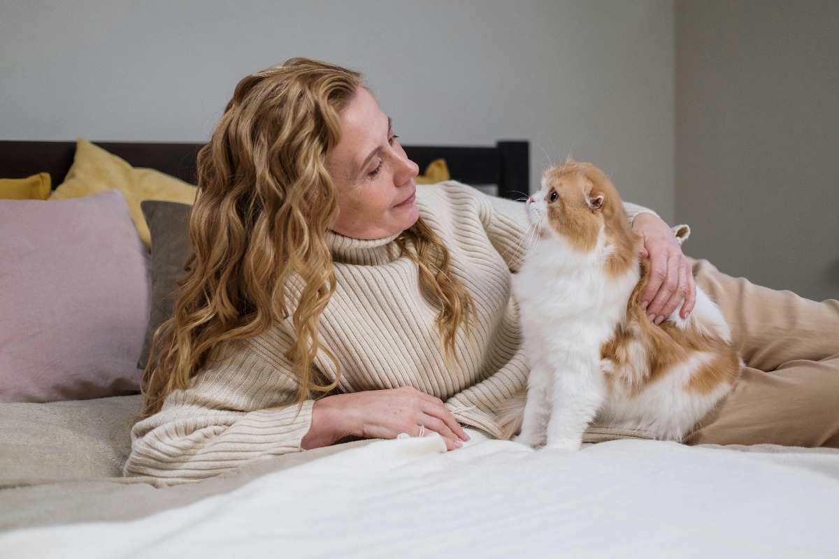 Pisică cu femeie în pat