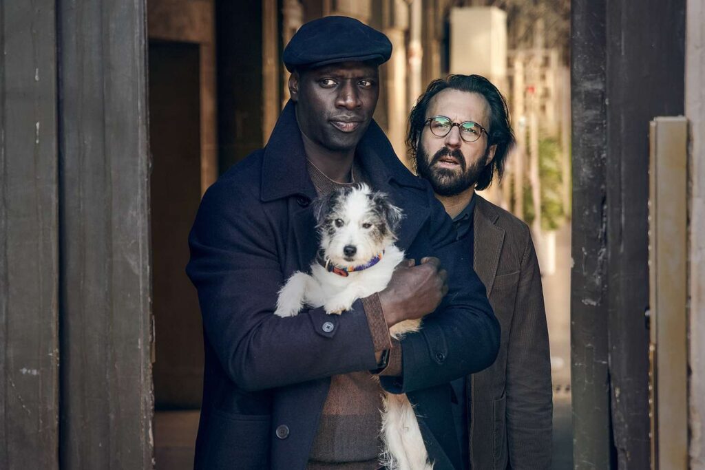 caine ținut în brațe de stăpân, în spatele lor este un bărbat