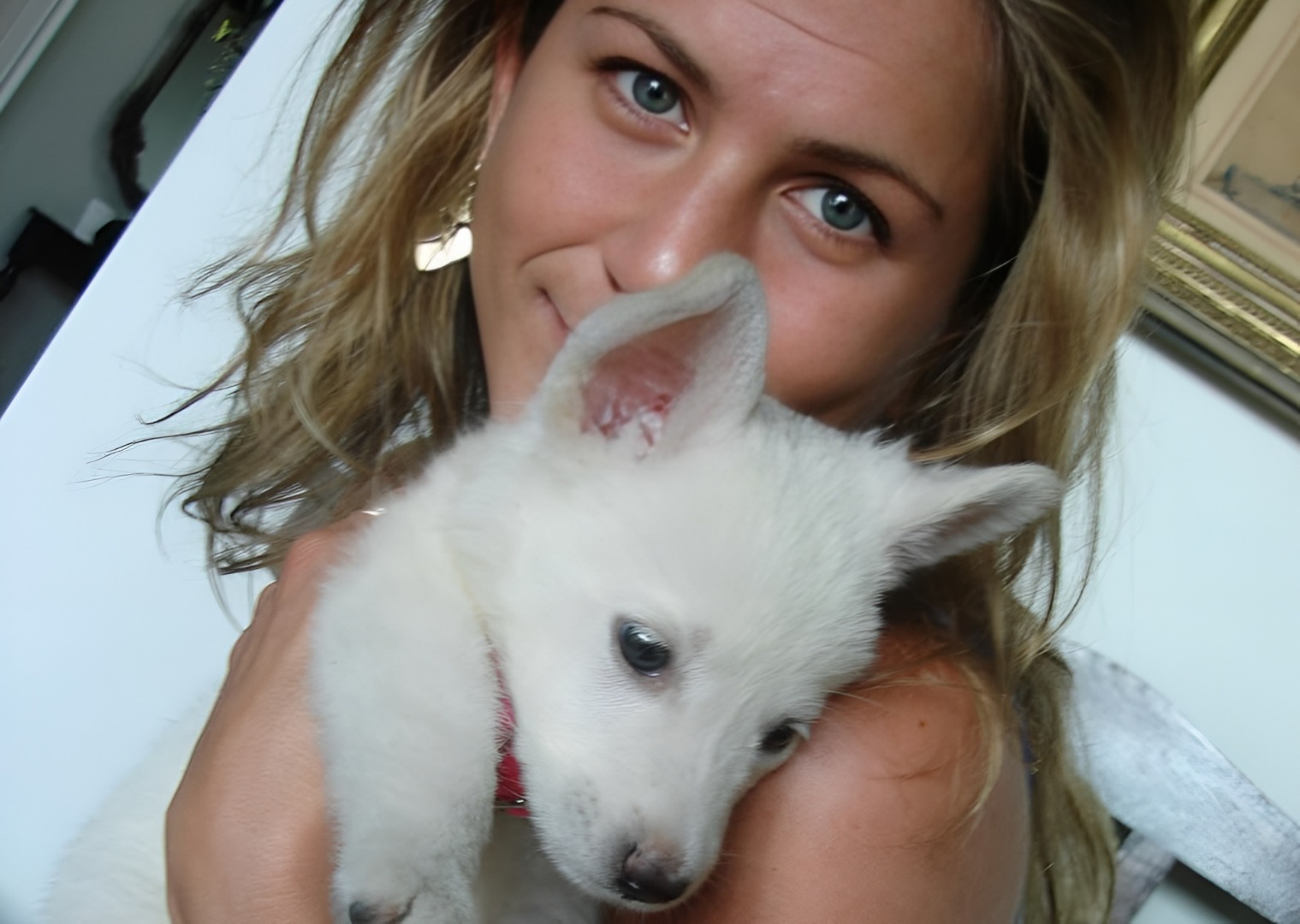 Actrița Jennifer Aniston alături de un cățel alb
