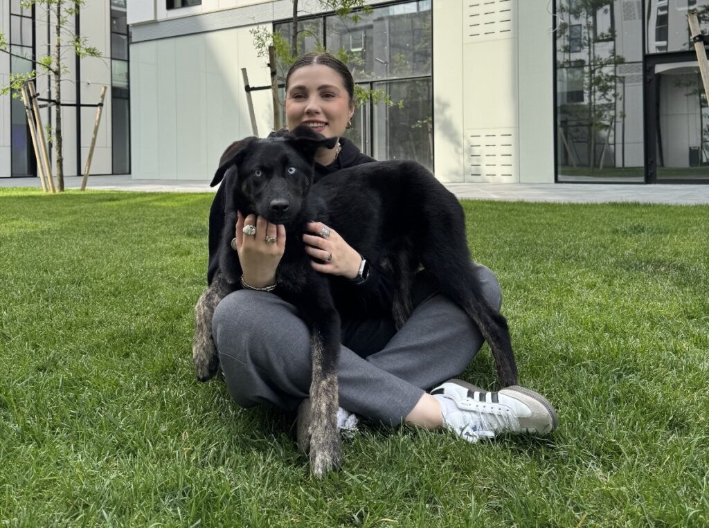 Tânără alături de un câine negru