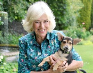 Regina Camilla ține un câine în brațe