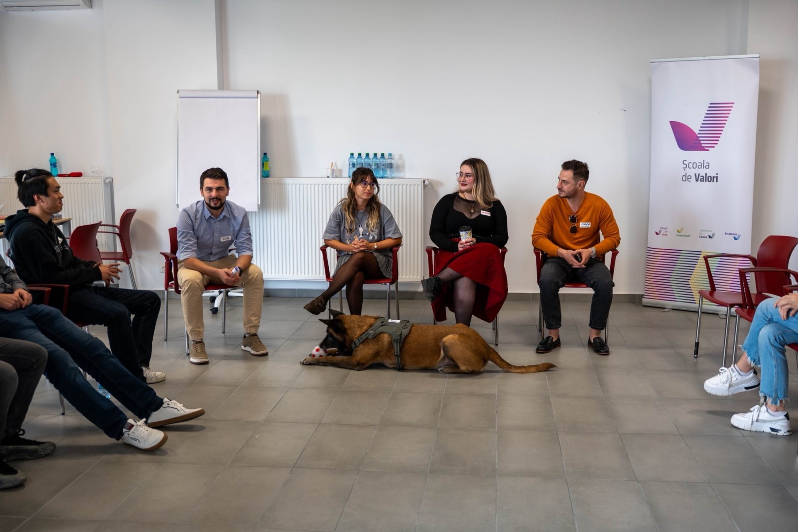 Mai multe persoane și un câine în cadrul unui eveniment