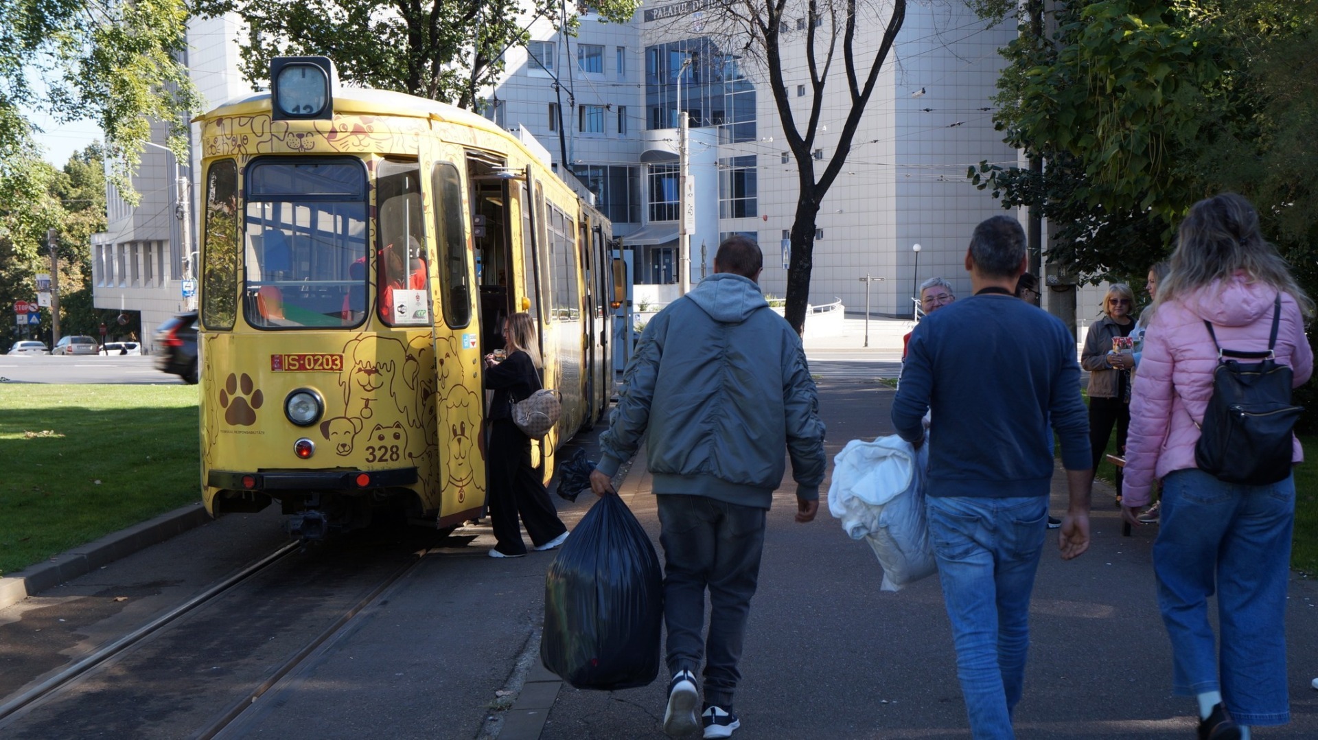 Oameni care se îndreaptă către un tramvai