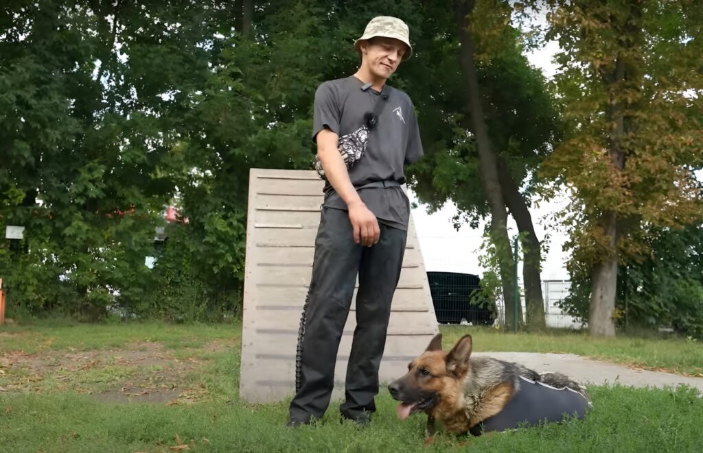 Bărbat fără o mână alături de un câine