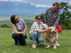 Jurnalista Ioana Cosma alături de două persoane și un câine