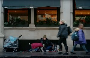 Un om fără adăpost alături de câinele său, pe stradă