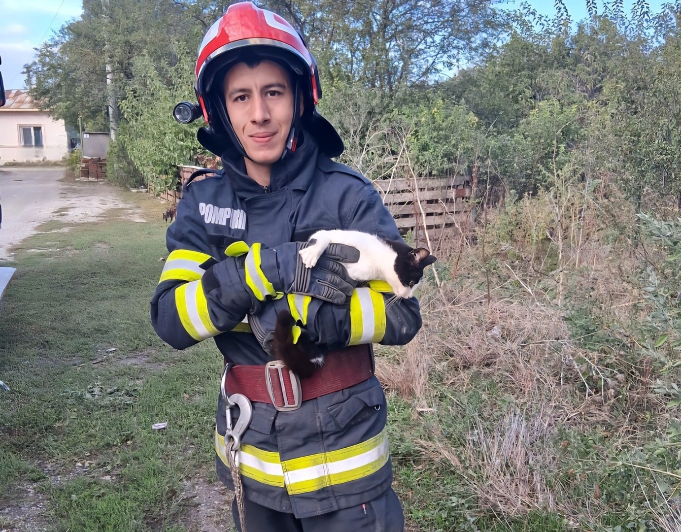 Un pompier ține în brațe pisica pe care a salvat-o