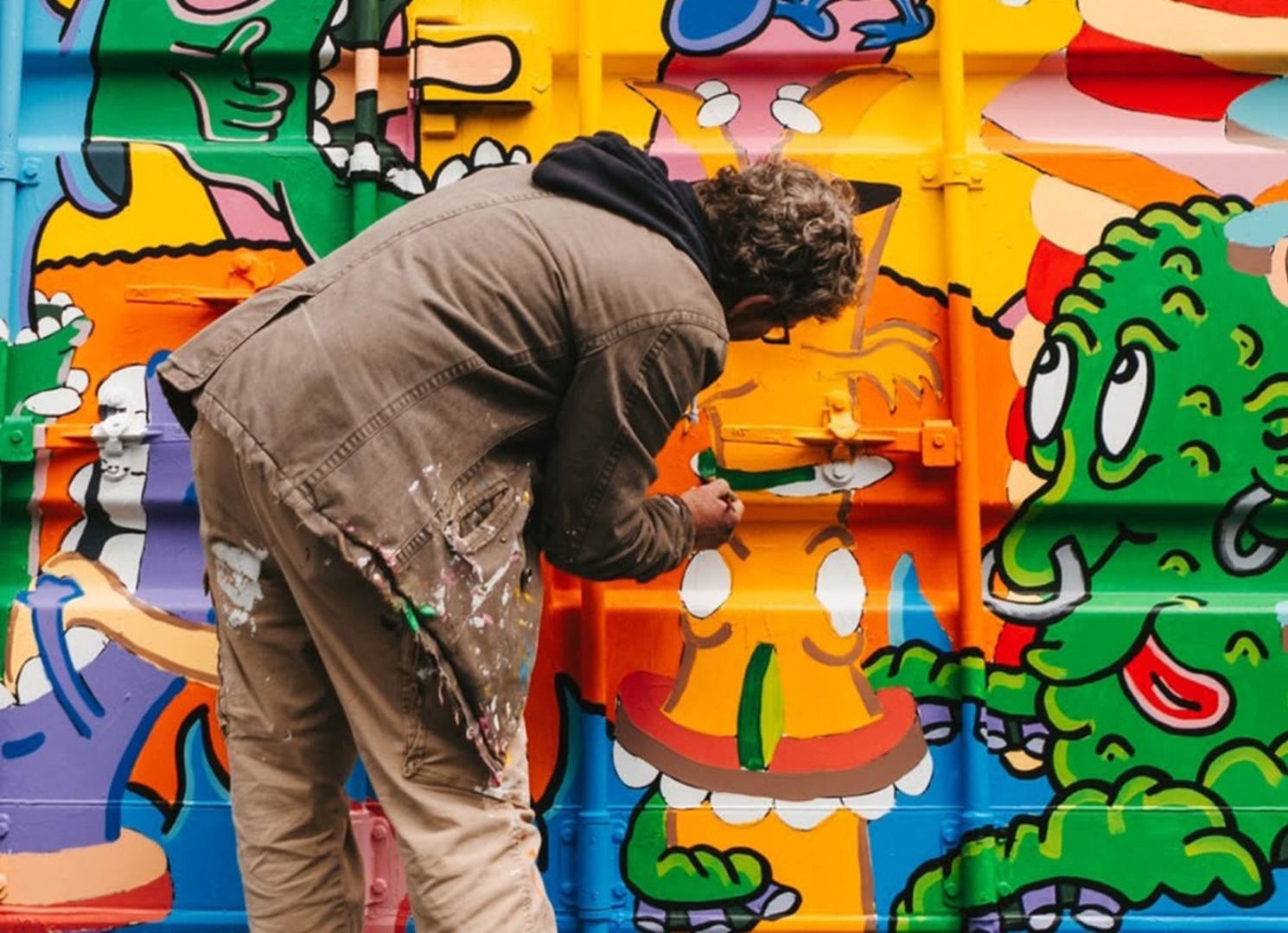 Un artist stradal realizează un graffiti