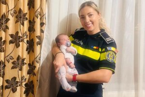 O polițistă ține în brațe un bebeluș