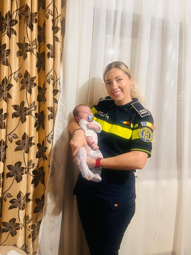 O polițistă ține în brațe un bebeluș