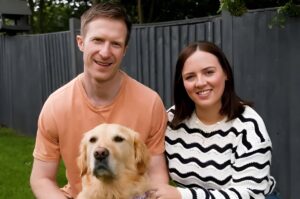 Un câine alături de stăpânii lui