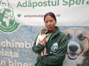 Angată nepaleză de la adăpostul Speranța are în brațe un cățel