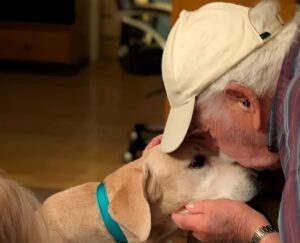 Un bătrân își sărută câinele