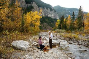 Un bărbat își cere iubita de soție pe munte, iar câinele este martorul momentului