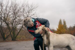 O voluntară de la Cruceca Roșie Ucraina mângâie un câine