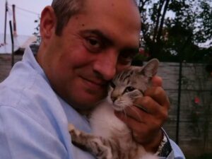 Sociologul Gelu Duminică ține în brațe o pisică