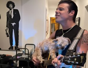 YungBlud cândtă la chitara pe care se află un cățel