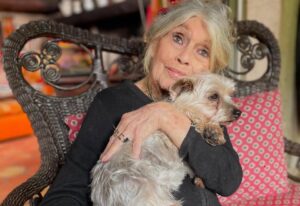 Brigitte Bardot ține un câine în brațe