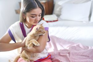 O tânără își ține pisica în brațe