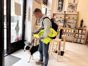 Un bărbat și câinele său ies dintr-o cafenea pet-friendly