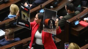 Un parlamentar polonez ține în mână afișe cu câini în lanț