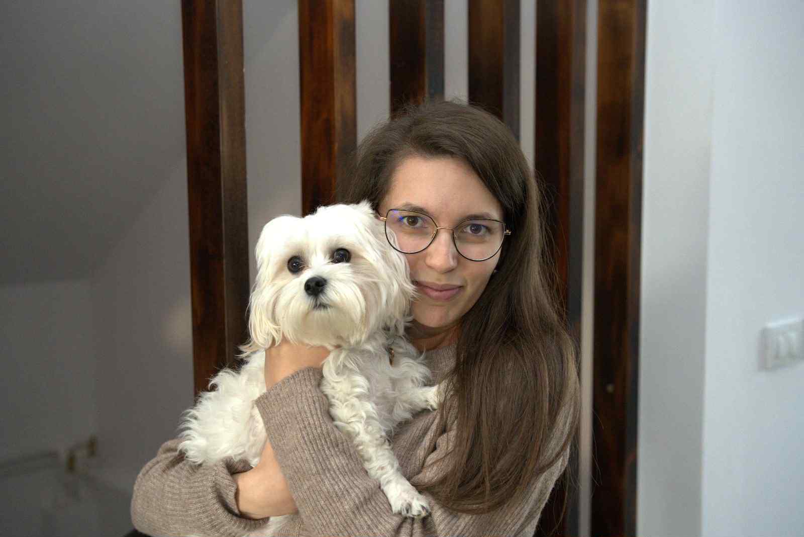 Câine ținut în brațe de stăpâna lui